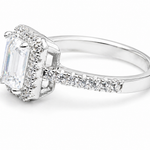 Side view of emerald cut moissanite ring with diamond halo band