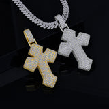 Two cross-shaped pendants, one gold and one silver, on a dark background.