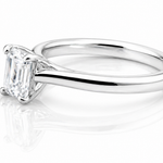 Classic Emerald Cut Moissanite Solitaire Ring 1CT | GRA Certified featuring a sleek, polished band with a sparkling emerald cut moissanite centerpiece.