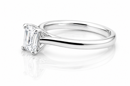 Classic Emerald Cut Moissanite Solitaire Ring 1CT | GRA Certified featuring a sleek, polished band with a sparkling emerald cut moissanite centerpiece.