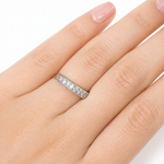 Close-up of a hand wearing the Moissanite Half Eternity Band – 1CT Round Cut VVS1 D Color | 925 Sterling Silver | GRA Certified Wedding Band for Women, sparkling with round cut stones.