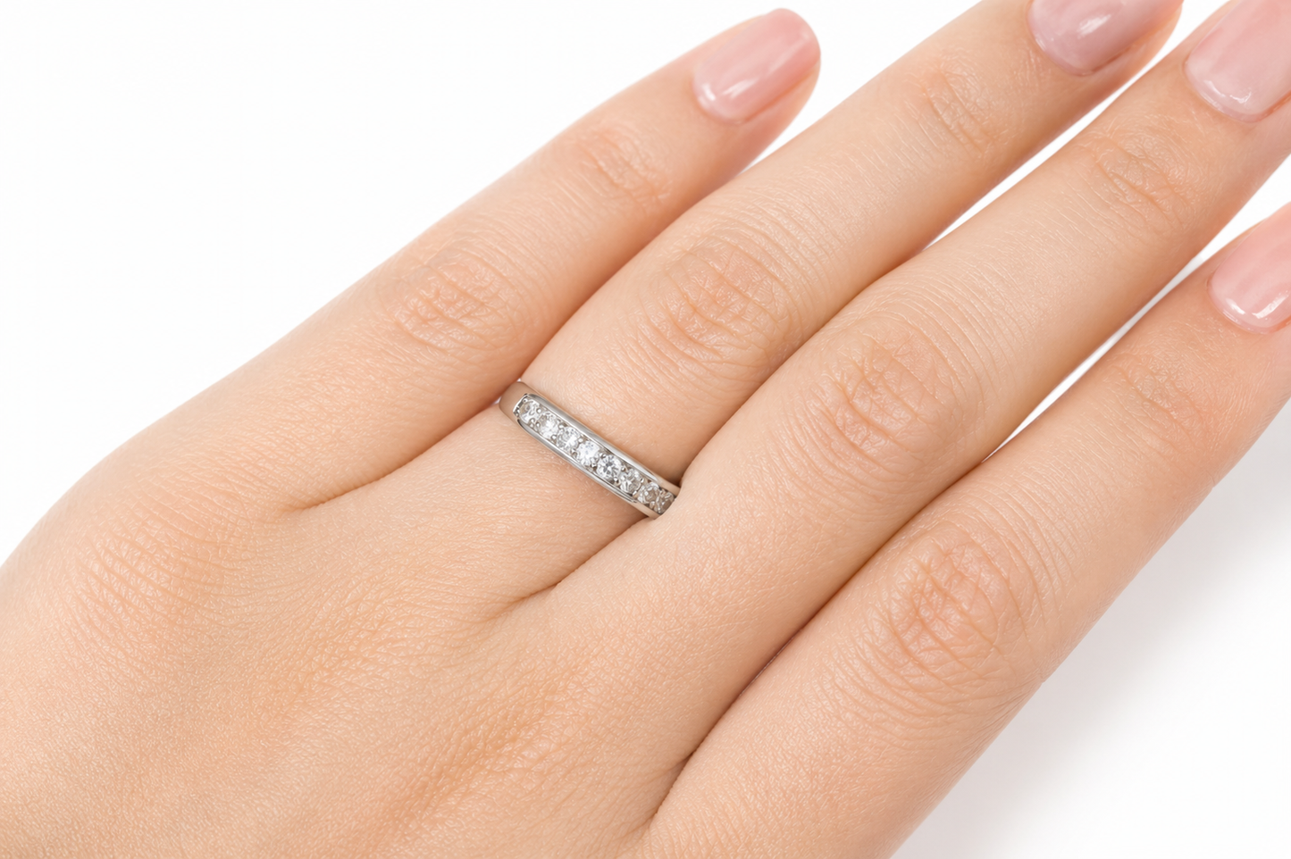 Close-up of a hand wearing the Moissanite Half Eternity Band – 1CT Round Cut VVS1 D Color | 925 Sterling Silver | GRA Certified Wedding Band for Women, sparkling with round cut stones.