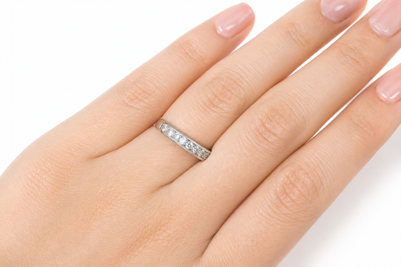 Close-up of a hand wearing the Moissanite Half Eternity Band – 1CT Round Cut VVS1 D Color | 925 Sterling Silver | GRA Certified Wedding Band for Women, sparkling with round cut stones.